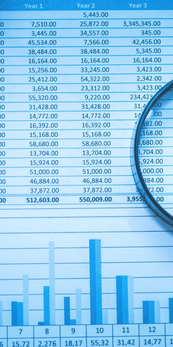 Spreadsheet bank accounts accounting with calculator and magnifying glass. Concept for financial fraud investigation, audit and analysis.
